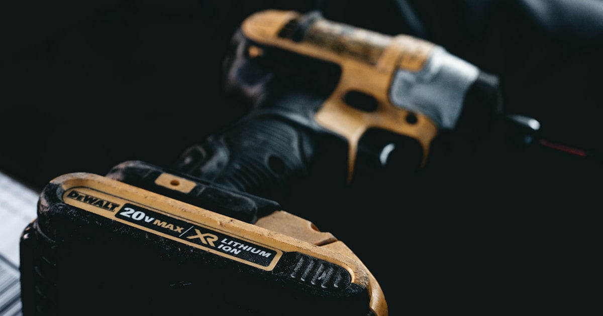 Cordless power tool batteries from multiple brands on a workbench